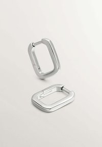 Pendientes de metal plateado en forma rectangular con bordes redondeados, que presentan una textura lisa y una bisagra para su sujeción.