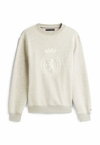 Lys beige crewneck sweatshirt med ribbede manchetter og kant, der har et diskret løvemotiv og teksten "Etableret 1985 Arv og Excellence" foran.
