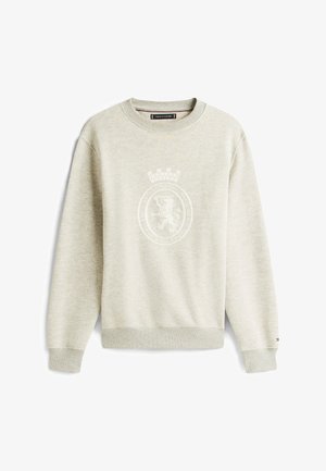Lichtbeige crewneck sweatshirt met geribbelde manchetten en zoom, met een subtiele leeuwenembleem en de tekst "Established 1985 Heritage and Excellence" op de voorkant.