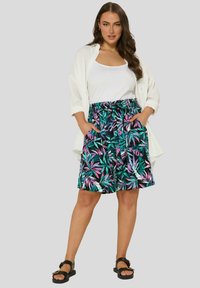 Shortsit kukkakuosisena, joissa on vihreää, violetista ja mustaa väriä, joustava vyötärö ja sivutaskut. Yhdistetty valkoiseen yläosaan ja kevyeseen päällyspaitaan.