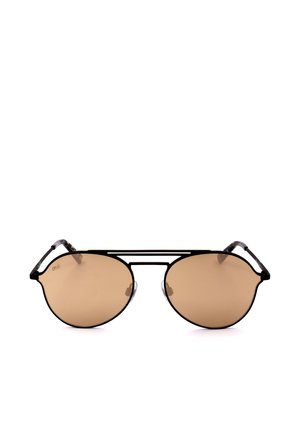 Occhiali da sole tondi con lenti marroni sfumate, montatura sottile in metallo nero e doppio ponte, posati su una superficie bianca.