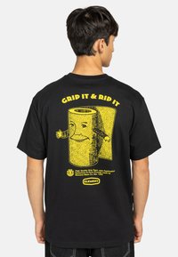 Black cotton t-shirt featuring a yellow graphic of a cartoon grip tape roll with arms, text saying "GRID IT & RIP IT" above and product details below.