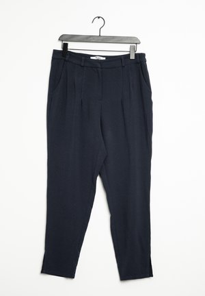 Pantalones entallados azul marino oscuro con pliegues delanteros y bolsillos laterales, colgados en una percha de plástico negra sobre un fondo blanco.