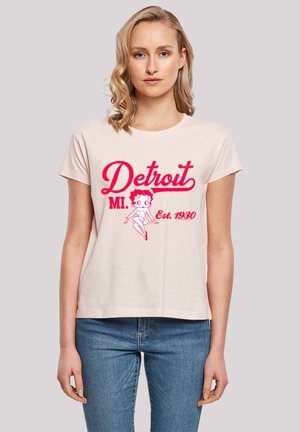Light pink cotton t-shirt featuring a red graphic design with the text "Detroit MI" and a cartoon character. Short sleeves and relaxed fit.