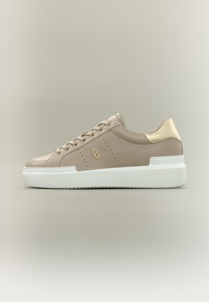 Beige leren lage sneaker met gouden hielaccent, veters aan de voorkant, "B"-logo op de zijkant en dikke witte rubberen zool.