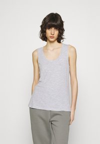 Šviesiai pilkas be rankovių marškinėlis su apvaliu kaklu, pagamintas iš minkštos, tekstūruotos medžiagos, turintis laisvą siluetą ir subtilų melangišką raštą.