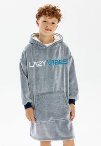 Grå fleece oversized hoodieklänning med texten "LAZY VIBES" i vitt och blått. Har en framficka och marinblå ärmar. Mjuk, texturerad tyg.
