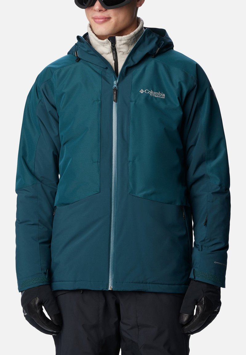 Teal isolierte Jacke mit Reißverschluss vorne, zwei Brusttaschen, verstellbarer Kapuze und schwarzen Handschuhen. Sie zeichnet sich durch einen glatten, leichten Stoff aus.