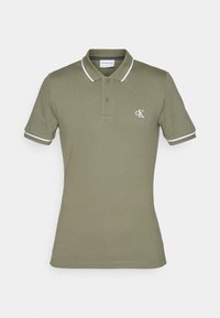 Polo shirt vert olive en coton, avec une patte de boutonnage à deux boutons, des bordures de col blanches et le logo CK sur la poitrine gauche. Manches courtes.