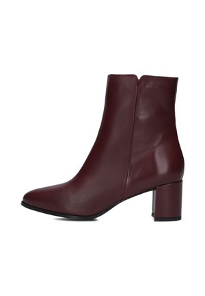 Bottines en cuir bordeaux avec un bout pointu, un talon bloc moyen et une fermeture éclair à l'arrière. Texture lisse et design épuré.