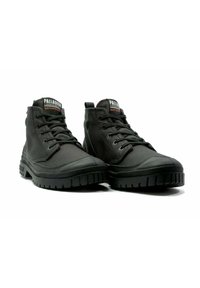 Bottes noires imperméables à la cheville avec une tige en toile, un embout en caoutchouc et une semelle antidérapante texturée avec des accents de logo sur la languette.