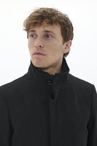 Manteau noir avec un col haut, design simple, fermeture à boutons et texture lisse, avec une coupe ajustée et des détails minimaux.