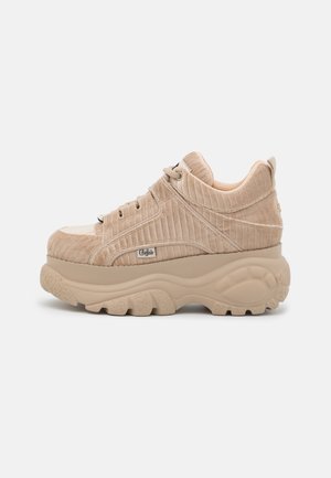 Beige stevige platform sneaker met ribfluweel textuur, vetersluiting en dikke gesculpteerde zool, zijaanzicht.