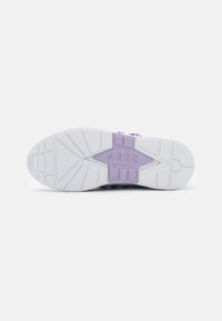 White sneaker outsole with purple accents, featuring a textured grip pattern and star logo detail. Lightweight and flexible design.