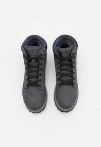 Bottes de randonnée en cuir gris avec un col rembourré, des lacets durables et une semelle en caoutchouc texturée. Présente des coutures contrastantes et un détail de logo.