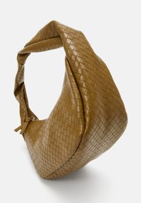 Bolso de cuero marrón tejido con un asa torcida, que presenta una forma suave y acolchada y un cierre con cremallera. Superficie texturizada con un patrón de cuadrícula.