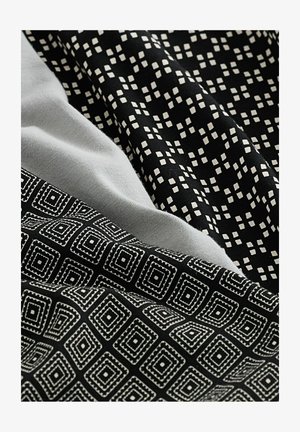 Tři vzorky tkanin: šedá bavlna, černá s malými bílými čtverečky a černá s geometrickým diamantovým vzorem obkresleným bílou.