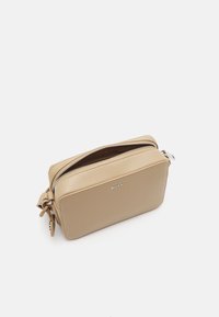 Borsa rettangolare in pelle beige con zip superiore e dettaglio del logo, caratterizzata da una texture liscia e un accento con fiocco laterale.