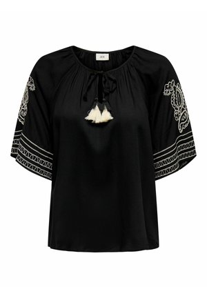 Svart blus med korta, lösa ärmar, prydd med vita broderade detaljer och fransar vid halsringningen. Slätt tyg med en avslappnad passform.