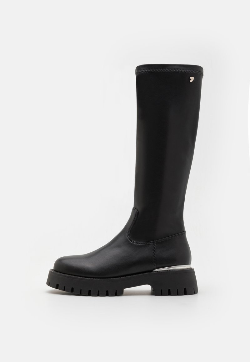 Bota negra de cuero hasta la rodilla con punta redonda, suela de goma gruesa y acento plateado en el tacón. Textura suave y diseño aerodinámico.