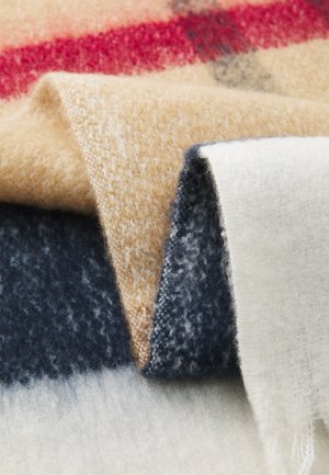 Wool blanket featuring a blend of beige, navy, and white sections, with a soft, fuzzy texture and subtle pattern throughout.