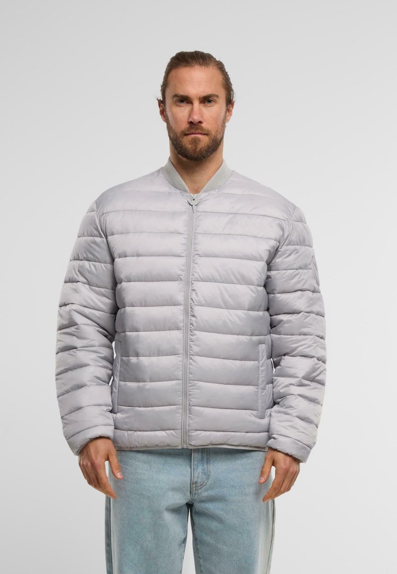 Grå polstret bomberjakke med lynlås foran, strukturerede lodrette sømme og sidelommer. Har en ribbet krave og en glat finish.