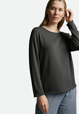 Dunkelgraues Langarmshirt mit rundem Ausschnitt, glatter Textur und lockerem Sitz, kombiniert mit hellblauen glänzenden Hosen.