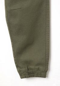 Olijfgroene tapered broekspijp met elastische manchetten, voorzien van een schone naad en een zijzak voor extra functionaliteit. Duurzame stof.