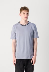 Lysegrå kortærmet T-shirt med rund hals, forsynet med en sort "BOSS" etikette på kraven. Glat, ensartet tekstur.