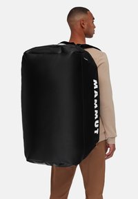 Zwarte Mammut rugzak met een rechthoekige vorm, gemaakt van duurzaam materiaal, met een groot ontwerp en een zijlogo in het wit.
