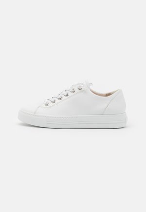 Sneaker de couro branco com bico arredondado, ilhós de metal e atacadores planos. Apresenta uma sola texturizada e um discreto detalhe de costura ao longo da borda.