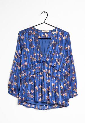 Blusa azul con estampado floral, mangas largas, escote en V y cintura fruncida. Hecha de una tela ligera con rayas verticales y acentos florales.