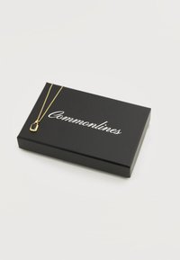 Guldvedhæng med sort rektangulær sten, der hviler på en sort boks med mærket "Commonlines" på en hvid baggrund.