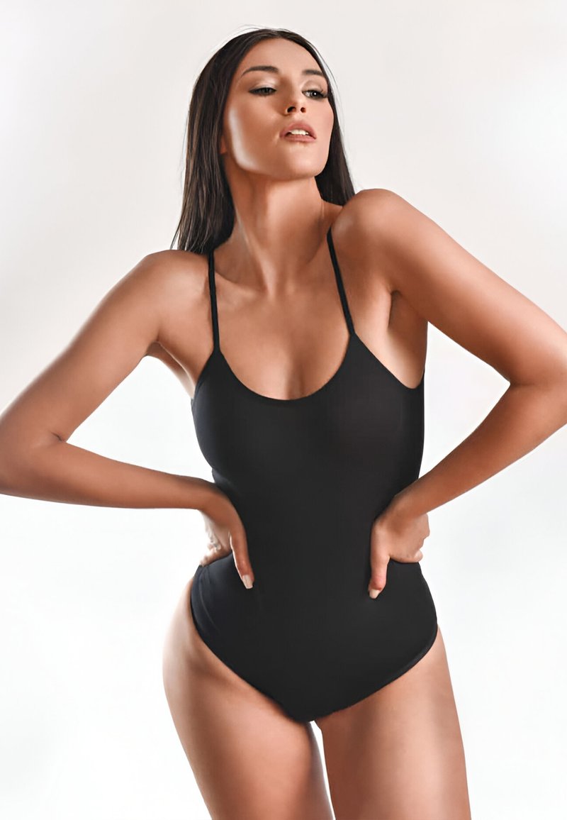 Zwart badpak met dunne bandjes, ronde hals en lage rug. Glad, stretchy stof, hoge beenuitsnijdingen en minimale details.