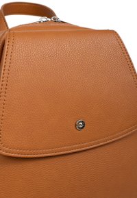 Zaino in pelle marrone con superficie texturizzata, pattina arrotondata, hardware argentato e un emblema con il logo sulla pattina, con cuciture tonali.