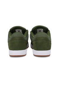 Zielone zamszowe trampki z wyściółką na kołnierzu, białymi podeszwami i brązowymi gumowymi podeszwami zewnętrznymi. Posiadają logo na czarnej metce wewnątrz buta.
