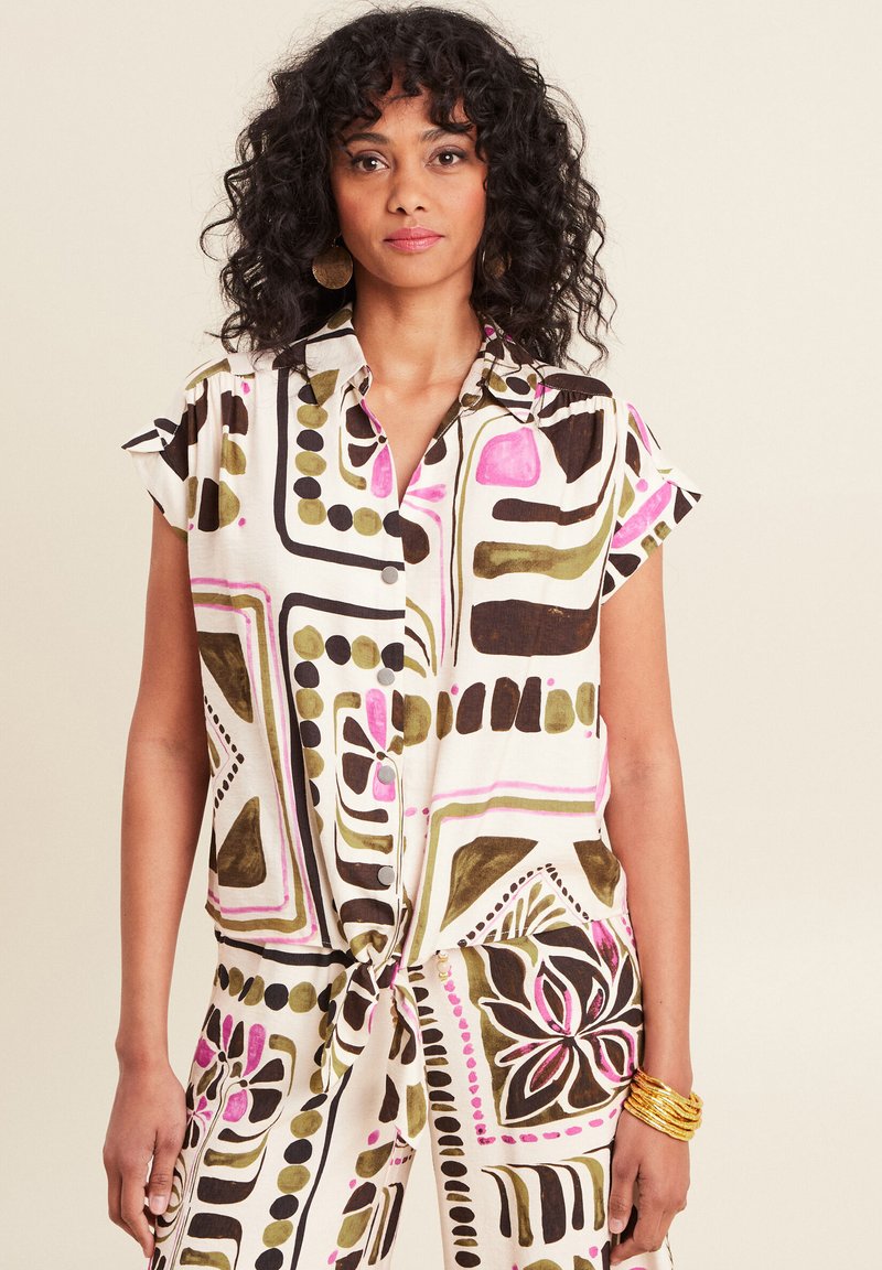 Kortemouwige, knoopsluiting blouse met een abstracte print in roze, groen en zwart op een witte achtergrond; knoopdetail in de taille.