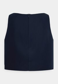 Top cropped azul marinho com uma textura suave, apresentando um decote reto e um fecho com zíper nas costas. Design limpo e minimalista sem adornos.