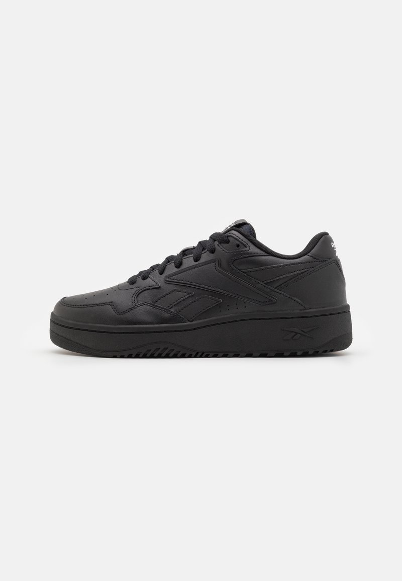Baskets basses en cuir noir avec fermeture à lacets, logo de marque sur le talon et le côté, et semelle en caoutchouc texturée.