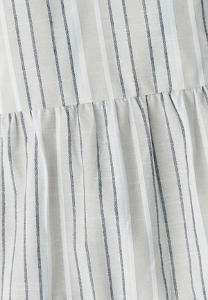 Lekka tkanina z pionowymi szarymi i białymi paskami, z marszczonym wykończeniem na dole, które dodaje wymiaru i wizualnego zainteresowania.