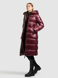 Bordo värvi puffer-tüüpi mantel kapuutsiga, tikitud mustriga, millel on narmendused ja küljetaskud. Kandmisel musta krobelise rõivastuse ja põlveni ulatuvate saapadega.