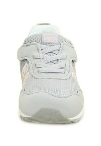 Sneaker grigio chiaro con accenti rosa, tomaia in rete, sistema di allacciatura, collo imbottito e suola in gomma per una migliore aderenza. Presenta il numero di modello "515".