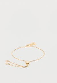 Pulsera de cadena de oro con un diseño delicado, que cuenta con un cierre ajustable y dos pequeños colgantes redondos. Textura suave con acabado brillante.