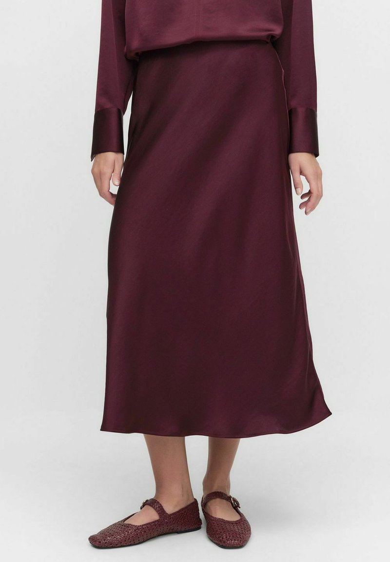 Burgunderfärgad satin midi-kjol med en slät textur, flödande design och subtil glans. Kombinationen med vinröda vävda flats med spänne.