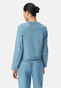 Jasnoniebieska kurtka dżinsowa o skróconym fasonie, z długimi rękawami i detalami szwów. Posiada okrągły dekolt oraz pas z tego samego materiału.