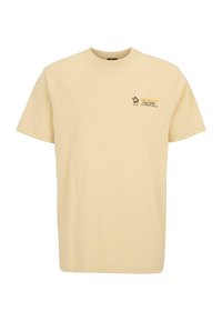 Camiseta de algodón beige de manga corta, con un pequeño diseño gráfico y texto en la zona izquierda del pecho. Estilo clásico de cuello redondo.