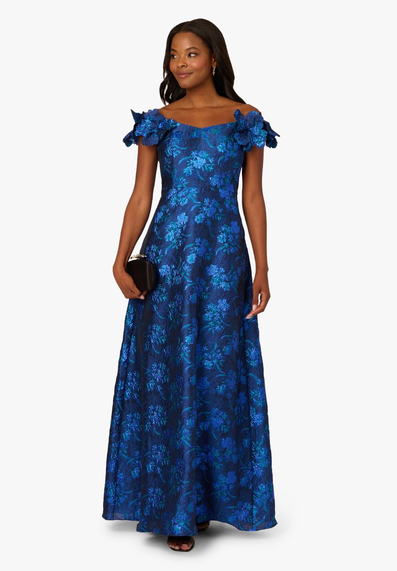 Robe de soirée florale bleue avec des manches à volants dénudées, un corsage ajusté et une jupe fluide. Présente un tissu texturé et des poches latérales.