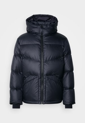 Casaco acolchoado em azul marinho escuro. Apresenta gola alta, fecho de correr e dois bolsos frontais. O material parece liso e brilhante.