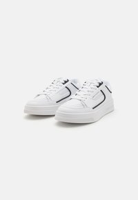 Adidași albi cu un toc din piele netedă, accente negre în contrast, design texturat și tălpi din cauciuc pentru aderen�ță și durabilitate.
