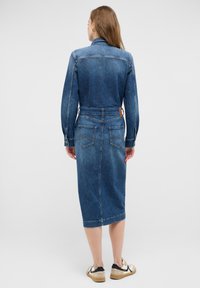 Zila denim midi kleita ar pieguļošu jostu, pogu aizdari, garām piedurknēm un divām aizmugurējām kabatām ar kontrastējošiem šuvju akcentiem.